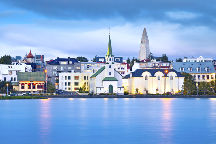 Reykjavík - Aussicht auf traditionelle Holzkirche am Ufer der Bucht, Kirch Hallgrímskirkja im Hintergrund