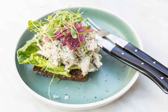 Typical Danish dish of Smørrebrød, served on a ceramic plate, with silverware